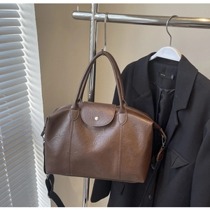 Detail of vintage brown textured leather tote with metal buckle and wide strap