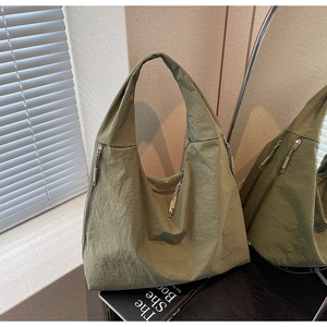 Détail du cabas en nylon vert armée avec texture plissée et poches zippées pratiques