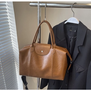 Detailed view of the brown lychee pattern leather tote bag with metallic snap closure