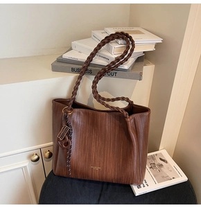 Detail of vintage woven texture on dark brown leather tote bag with braided handles