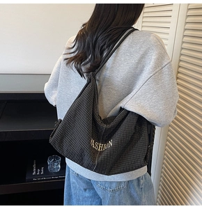 Detail of checkered canvas hobo bag showing the large capacity and fashion metal logo