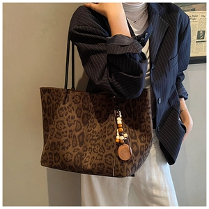 Dettaglio della borsa tote leopardata con nappa in perline di legno e ampio spazio