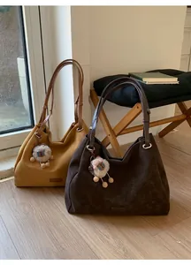 Detail of vintage suede hobo bags in ginger and dark brown with cute sheep charms