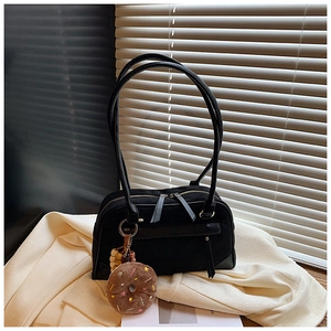 Detail of black suede Boston bag featuring double zippers and cute plush doughnut charm