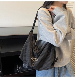 Detail of checkered hobo bag showing large capacity and fashion text on shoulder strap