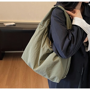 Détail du sac fourre-tout en nylon vert armée avec texture plissée et design drapé