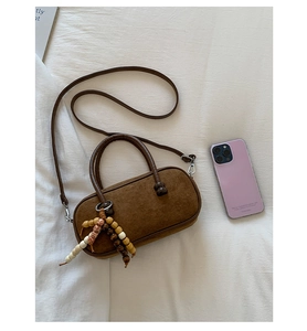 Dettaglio borsa Boston vintage in pelle scamosciata marrone con ciondolo in legno e perline