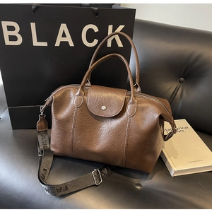 Detail of dark brown leather tote featuring retro pebble texture and fashion wide strap
