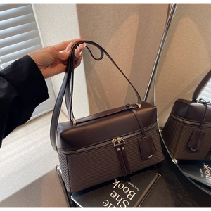 Detail of a deep brown faux leather handbag with textured stitching and dual shoulder straps