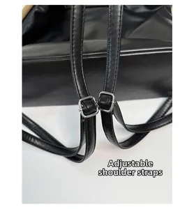 Detail of black leather backpack straps featuring adjustable silver square metal buckles