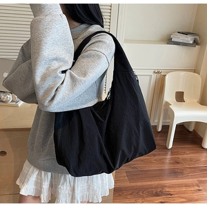 Gros plan sur un sac cabas en nylon noir texturé dans un bureau à domicile minimaliste