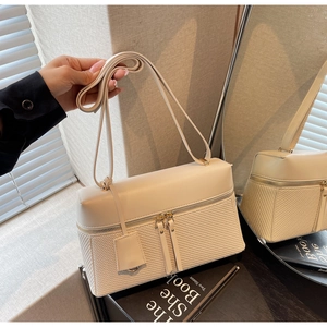 Close-up of beige shoulder bag showing the premium textured weave and smooth leather patchwork