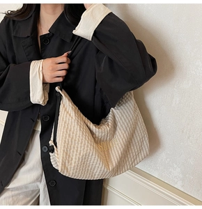 Detail of checkered canvas tote bag with fashion embroidery and black woven strap