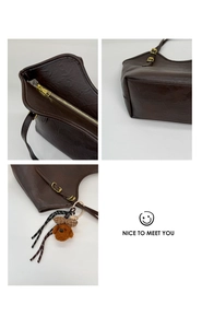 Detailansicht braune Shopper-Tasche mit Metallreißverschluss und Plüsch-Anhänger
