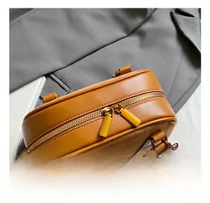 Detail of brown leather shell bag with gold double zippers and premium hardware finish