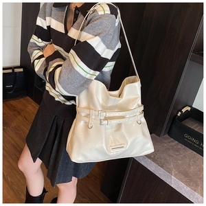 Dettaglio della grande borsa a tracolla crema con cinturini a fibbia per look casual