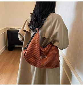 Brown checkered canvas tote bag with black drawstring strap on model's shoulder