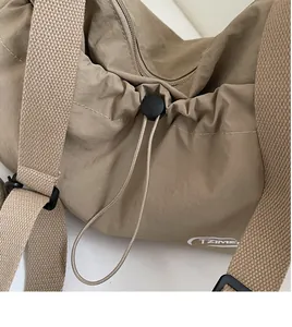 Dettaglio della borsa in nylon kaki con chiusura a coulisse e fermaglio nero