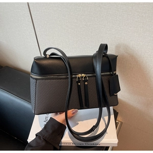 Detail of minimalist two-tone leather shoulder bag with gold zipper and textured finish
