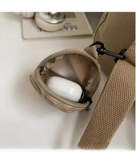 Dettaglio della custodia per auricolari in tela kaki con gancio nero su borsa