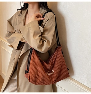 Detail of red-brown checkered hobo bag with gold embroidery and drawstrings