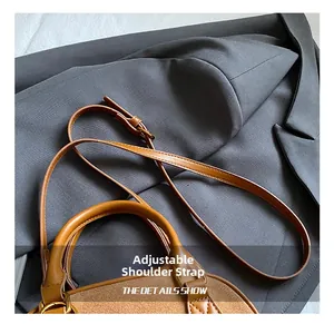 Detail view of caramel brown pillow bag featuring adjustable strap and vintage metal hardware