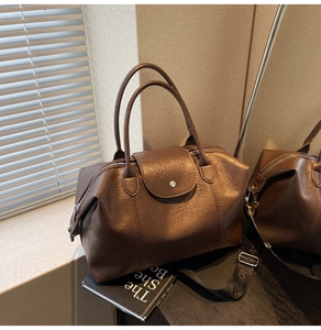 Detail of vintage brown PU leather texture and silver hardware on a Boston tote bag