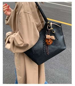 Detailansicht der schwarzen matten Ledershopper mit Teddybär-Anhänger und goldener Schnalle