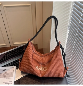Detail of a brown plaid hobo shoulder bag featuring golden lettering and woven rope straps