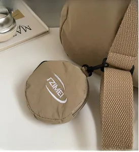 Dettaglio mini custodia in nylon kaki con ricamo IZIMEI e gancio per accessori nero