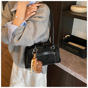 Close-up of black matte suede bag with unique doughnut charm and wooden beads detail