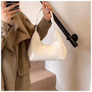 Détail du sac hobo blanc en cuir verni brillant avec une silhouette élégante en demi-lune