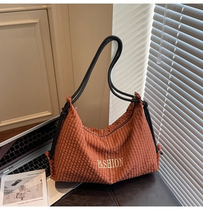 Detail of checkered shoulder bag with FASHION text and thick rope handle design