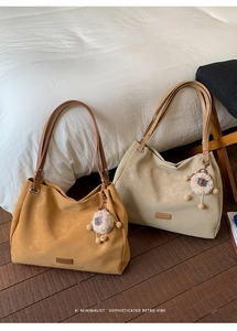 Close-up of retro matte suede tote bags in yellow and beige with plush sheep charms