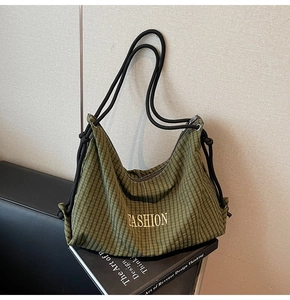 Detail of green plaid Hobo bag with FASHION text on Design Thinking book background