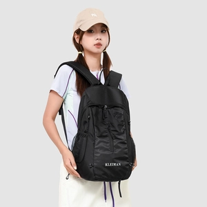 Detailed view of black athletic backpack with multiple compartments and mesh side pockets
