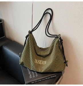 Detail of olive green checkered canvas tote featuring gold embroidery and rope handles