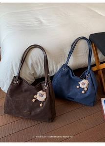Close-up of minimalist retro tote bags in dark brown and navy with plush sheep charms