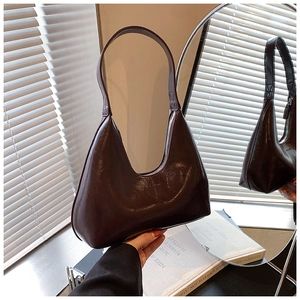 Détail du sac hobo marron foncé brillant avec fermeture éclair argentée et texture cuir