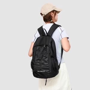 Detail view of durable black nylon backpack with brand logo on a side-profile model