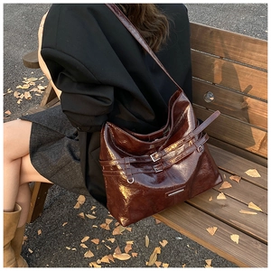 Scatto all'aperto di una borsa a secchiello vintage in pelle cerata marrone scuro con fibbia