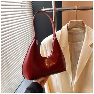 Détail d'un sac hobo bordeaux brillant avec une finition lisse et une fermeture éclair