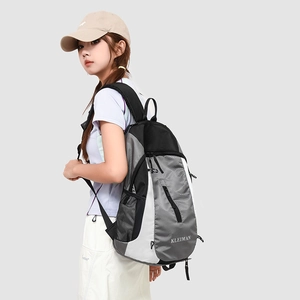 Side view of large sports backpack on model showing grey texture and mesh side pocket