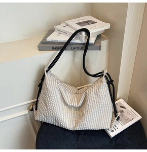 Detailed close-up of fashion letter embroidery on plaid hobo shoulder bag