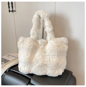 Detail of soft white faux fur tote bag showing plush texture on black leather seat