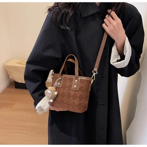 Detail of vintage brown textured bucket bag with patterned F motifs and plush charm