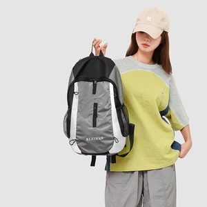 Detail view of water-resistant nylon texture and brand logo on functional grey backpack