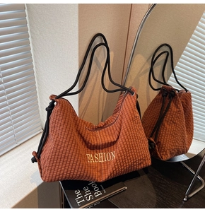 Close-up of brown plaid drawstring bag with yellow Fashion embroidery and rope strap