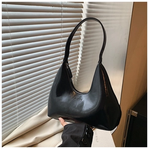 Détail du sac à bandoulière demi-lune noir avec finition brillante et relief