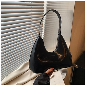 Détail d'un sac hobo noir chic avec logo et texture en cuir synthétique lisse
